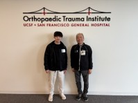 写真11.Orthopaedic Trauma Instituteのロゴを背景に.右が長尾教授.